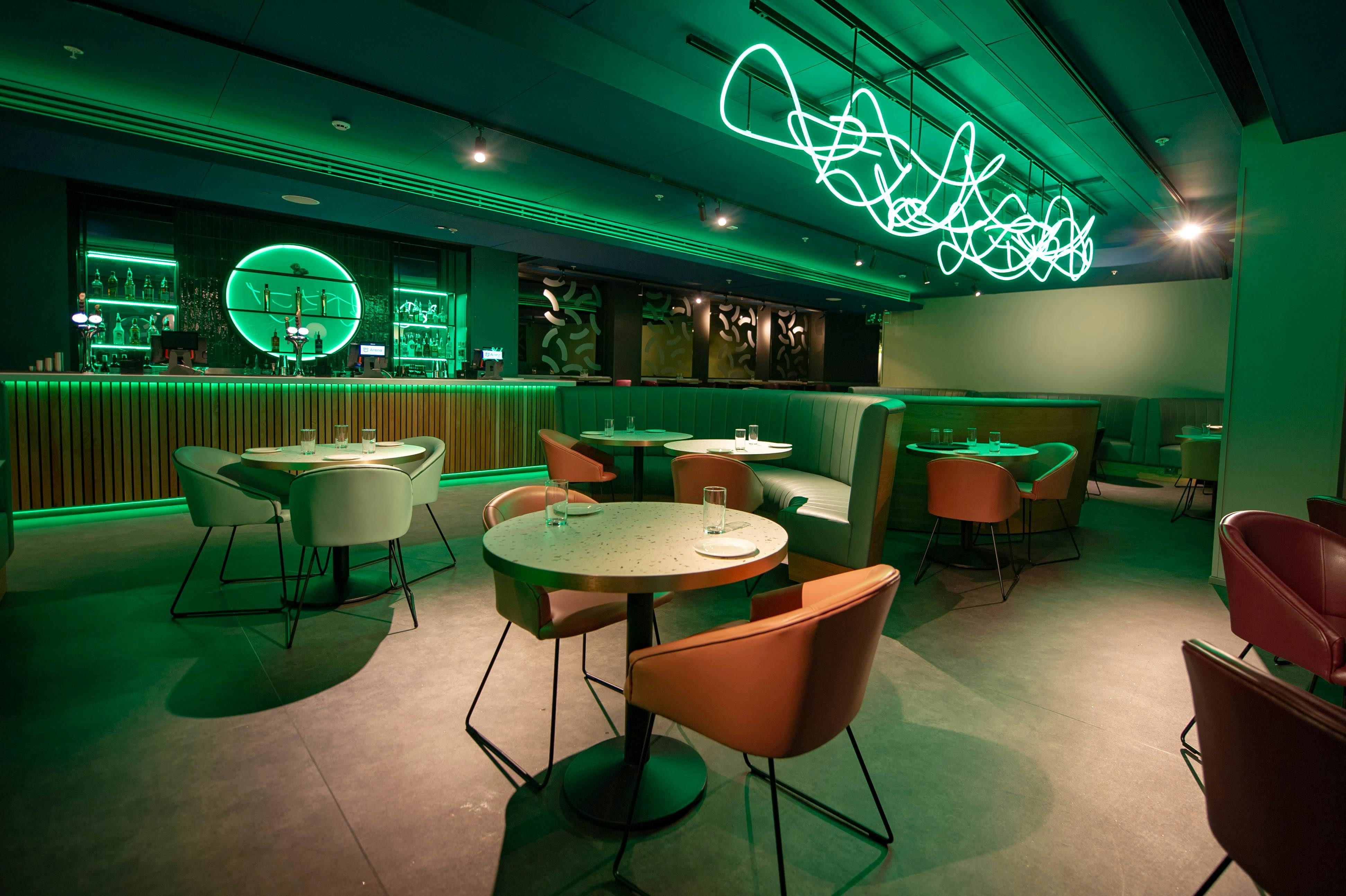 Luxury Suites at AO Arena with vibrant green lighting for networking events and gatherings.