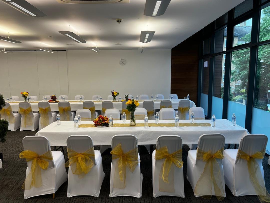 Emerald Suite in The Rock Tower: elegant meeting space with floral centerpieces and natural light.