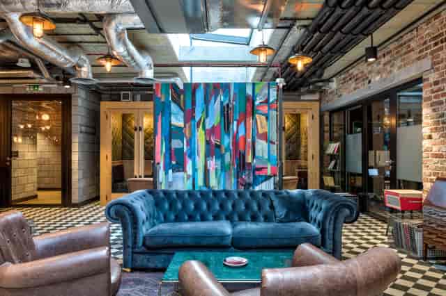 Modern event space with plush blue sofa, ideal for meetings and brainstorming sessions.