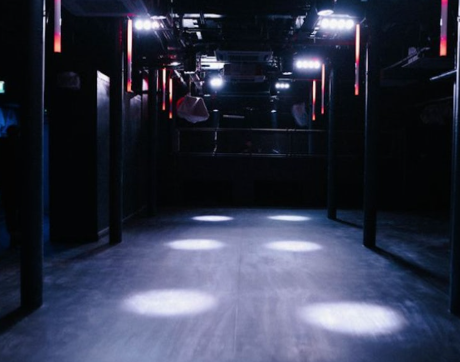 DOWNTEX MILL: Modern event space with dim lighting for networking and performances.