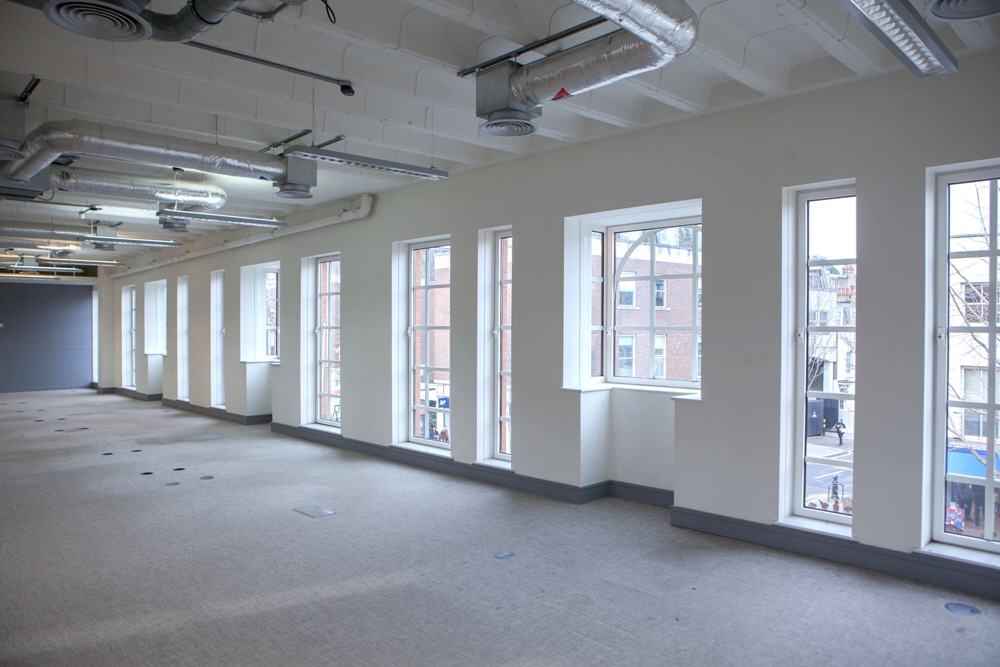 Spacious event space with large windows for meetings and workshops in Chelsea. - Banner