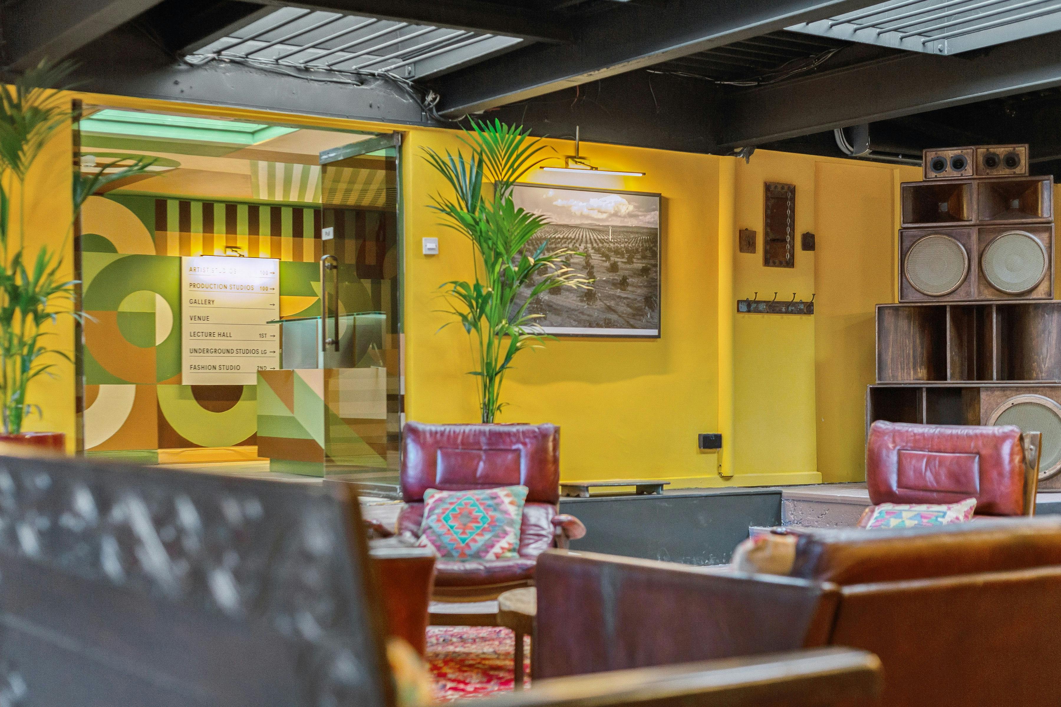 Intimate event space with warm yellow walls, perfect for meetings and gatherings.