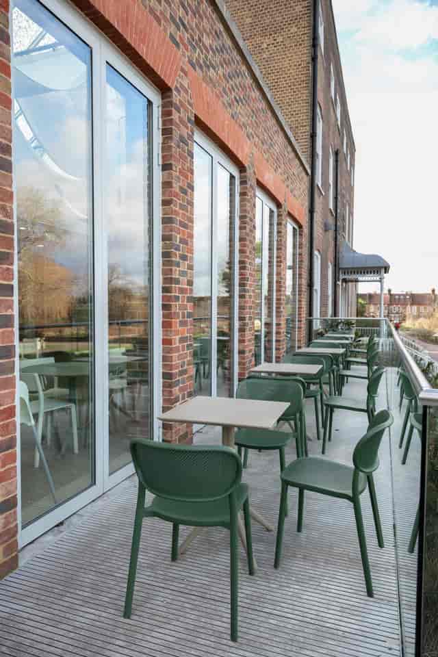 Modern outdoor seating area with green chairs at William Morris Gallery for networking events.