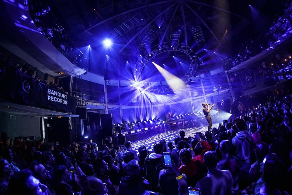 Live event in Rose Theatre's Main Auditorium with performer and vibrant lighting. - Banner