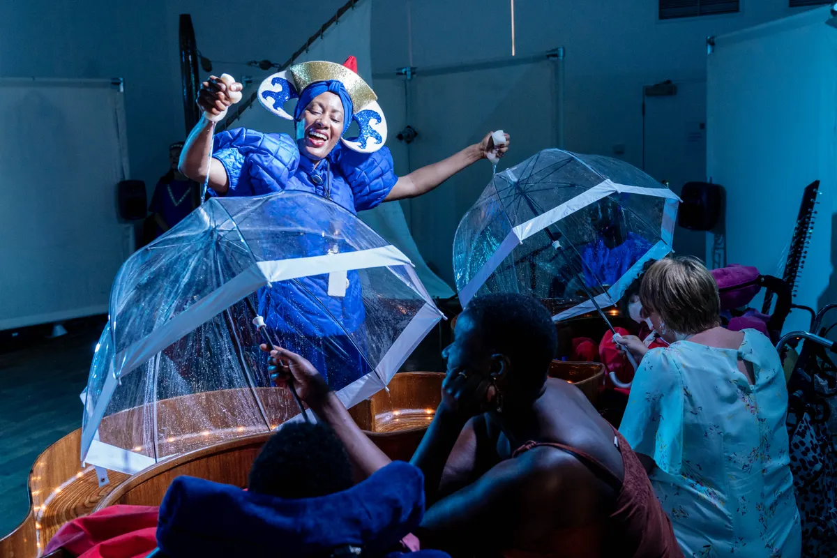 Vibrant performer under umbrellas at Rose Theatre for engaging event experiences. - Banner