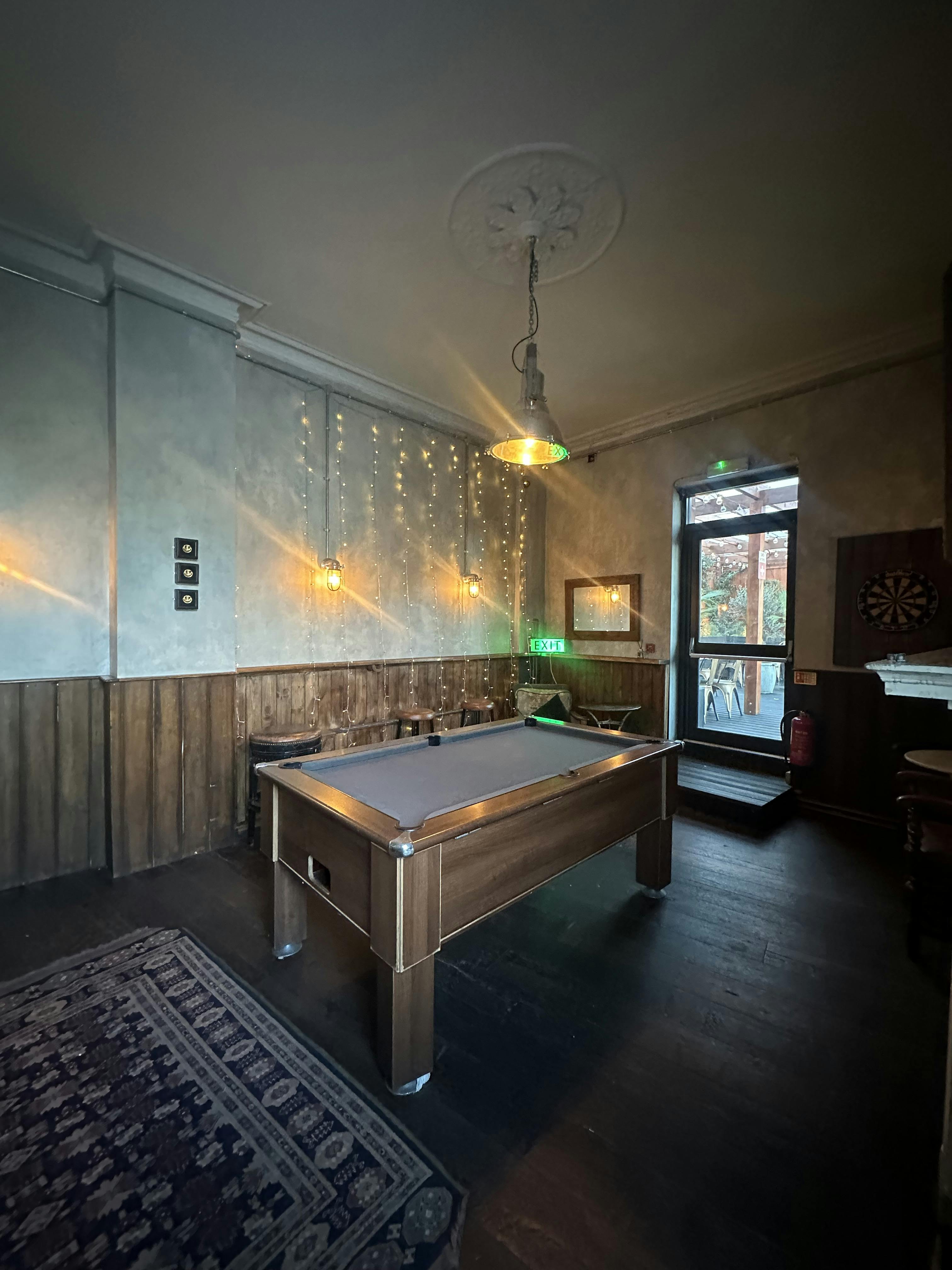 Cozy billiard room with pool table for team-building and networking events.