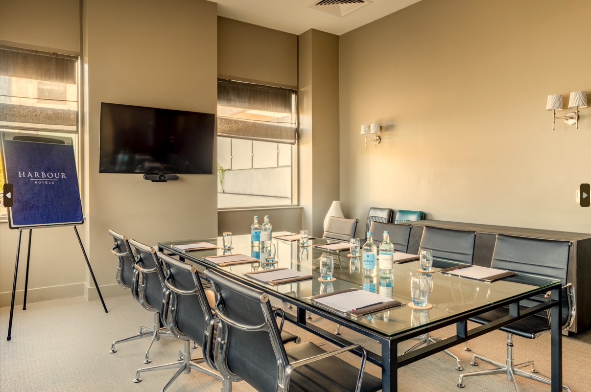 Modern meeting room at Guildford Harbour Hotel with glass table, ideal for workshops. - Banner