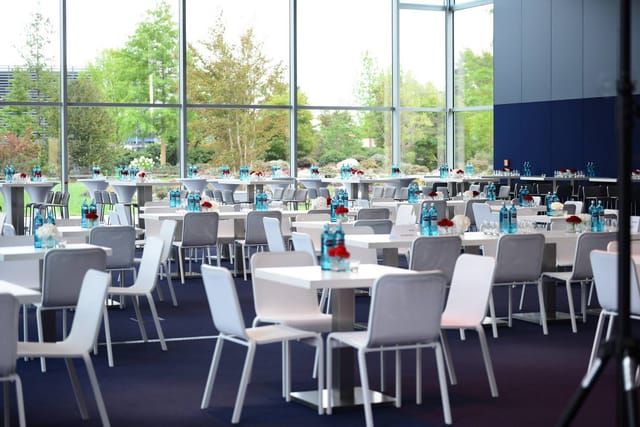 Modern event space with white tables, ideal for conferences and social gatherings.