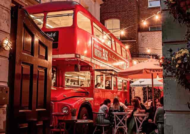 Vibrant outdoor event space with red double-decker bus for social gatherings and networking.