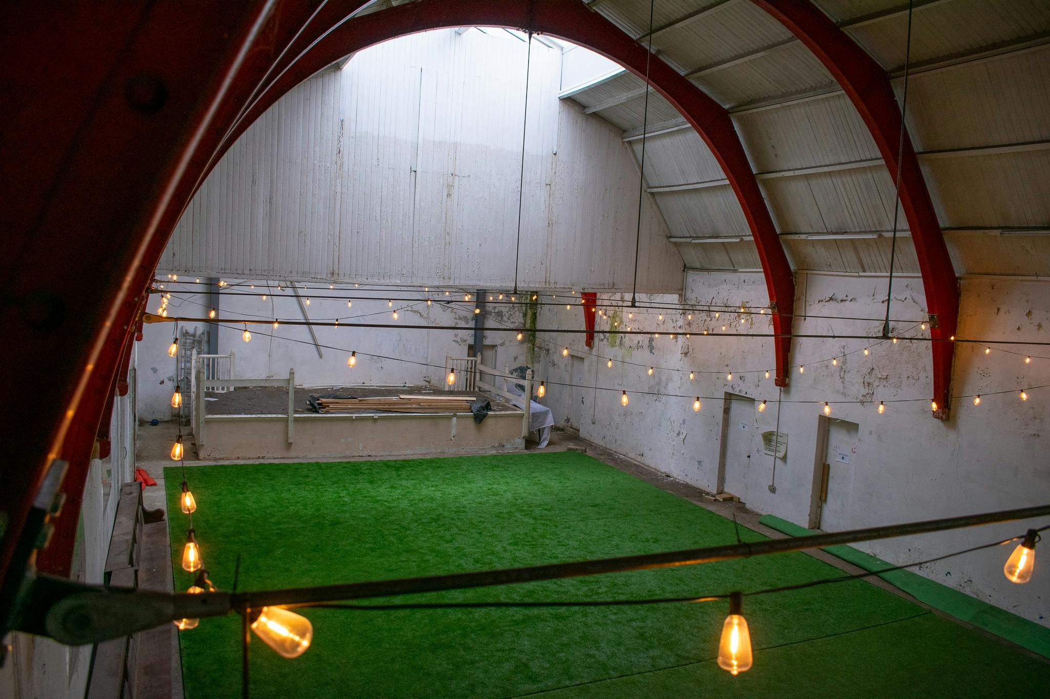 Versatile event space with artificial grass flooring for corporate meetings and workshops.