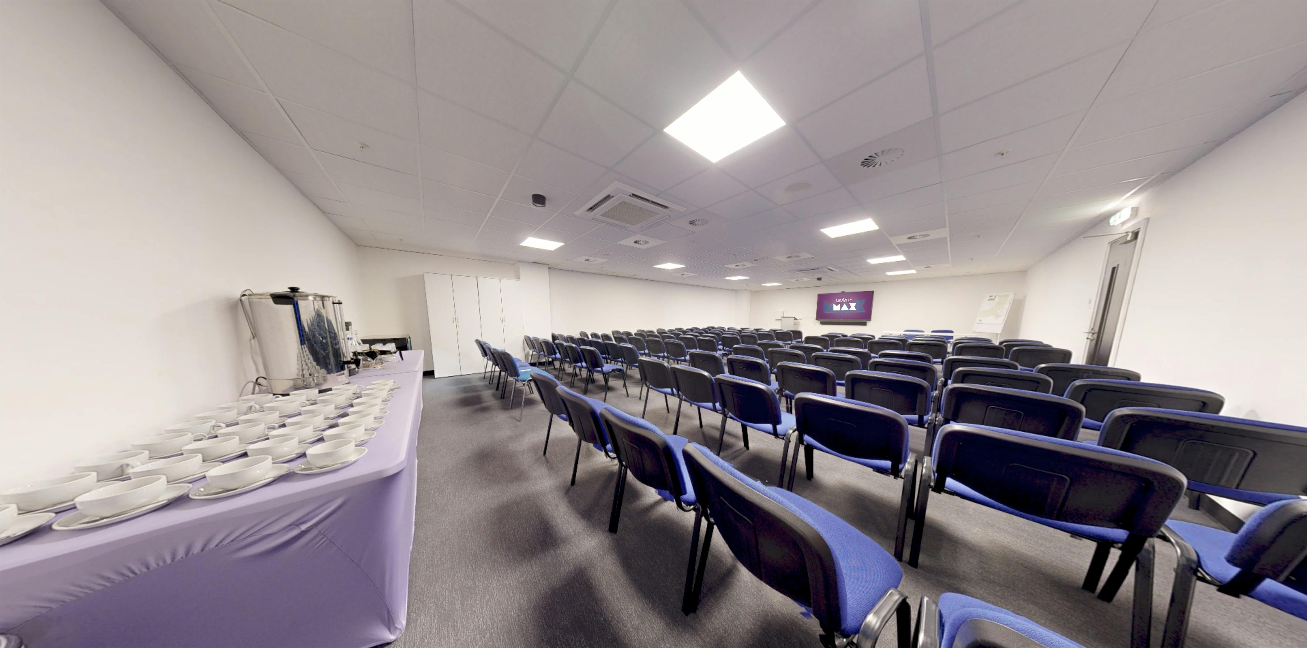 Meeting Room at Gravity Max with blue chairs, ideal for presentations and workshops.