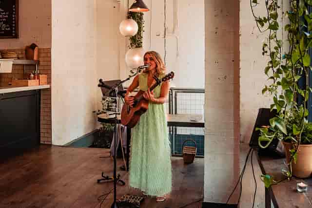 Vibrant event space with live musician at FARE Restaurant + Bar for networking gatherings.