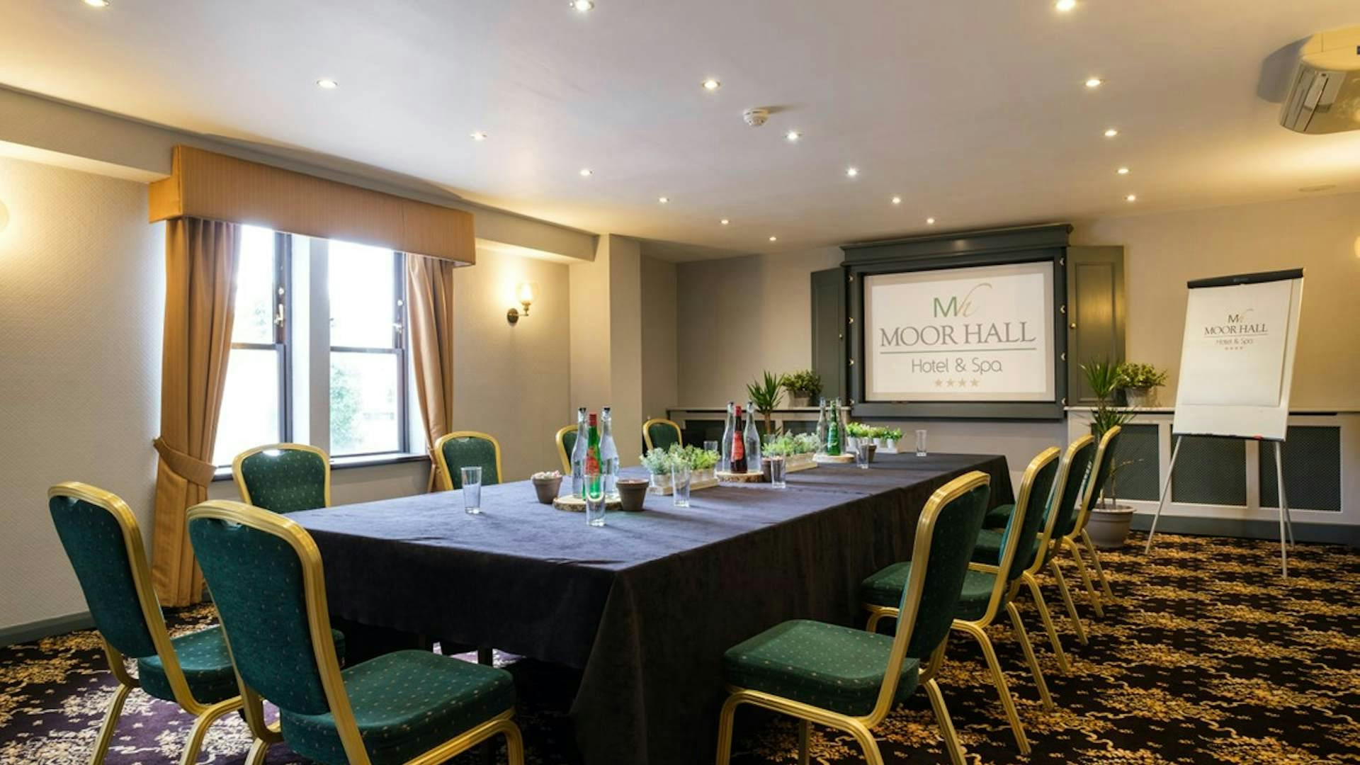 Longmoor Room at Moor Hall Hotel: elegant meeting space with natural light and green chairs.