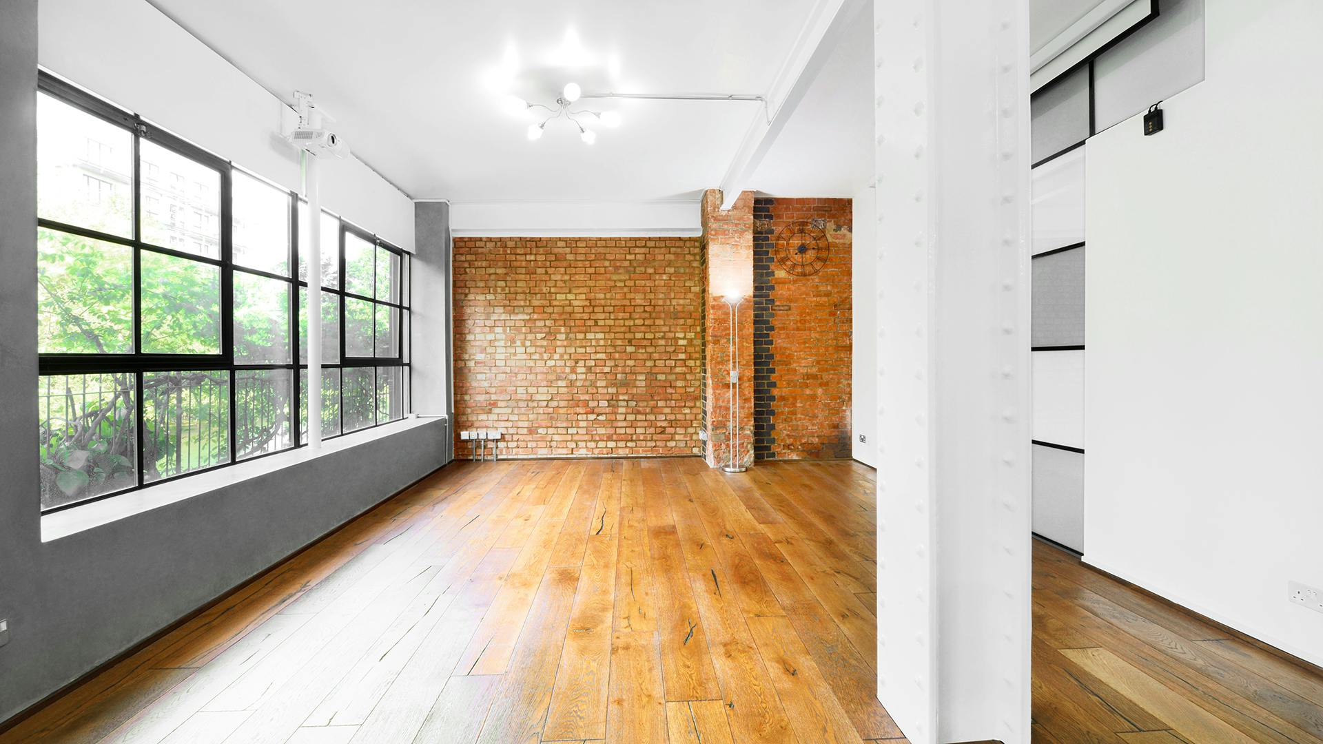 Versatile S1 Apartment event space with large windows for meetings and gatherings.