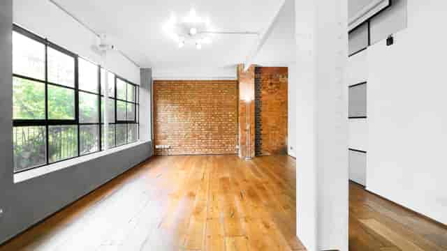 Versatile S1 Apartment event space with large windows for meetings and gatherings.
