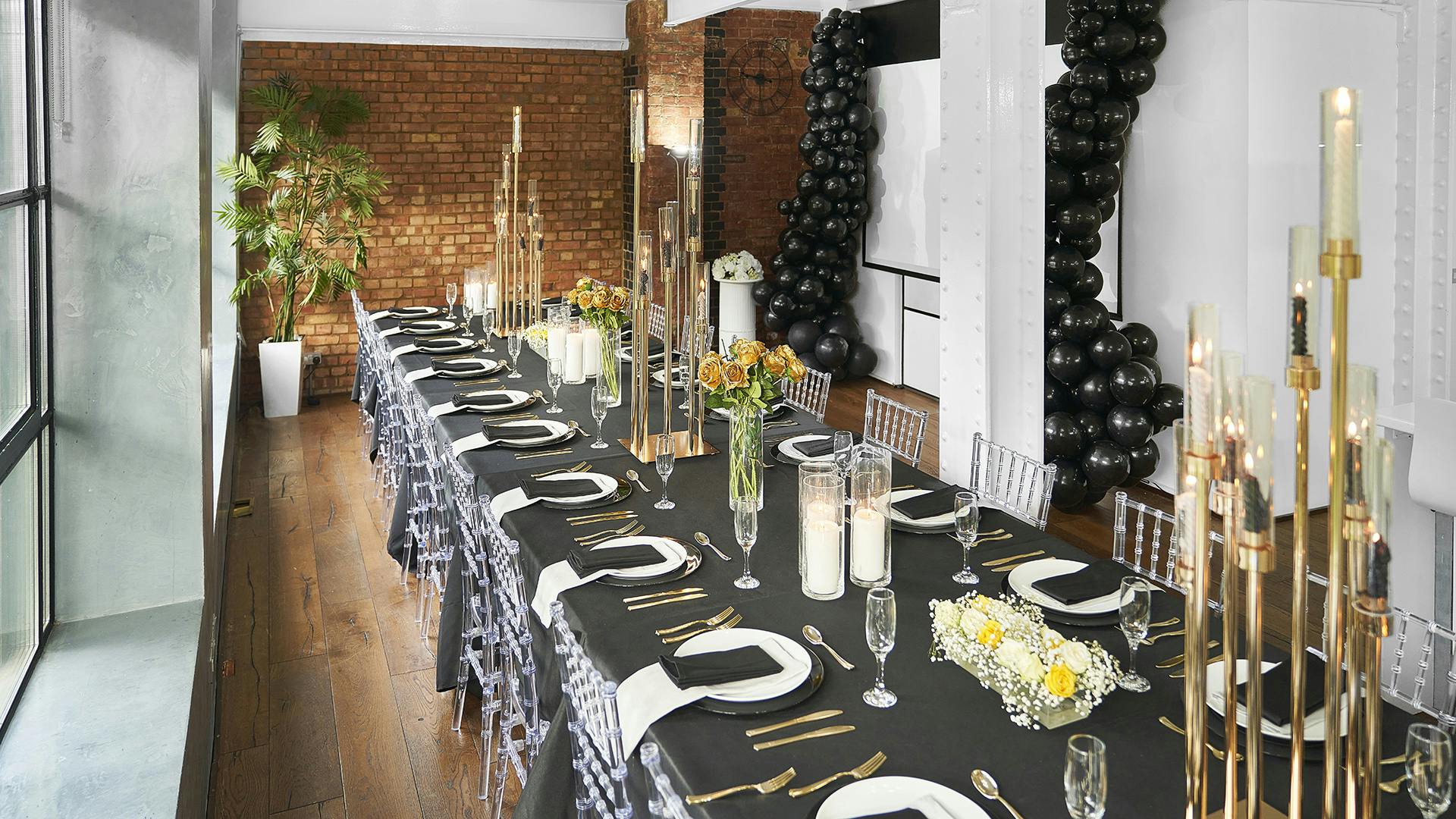 Sophisticated S1 Apartment event setup with elegant table, black linens, and gold accents.