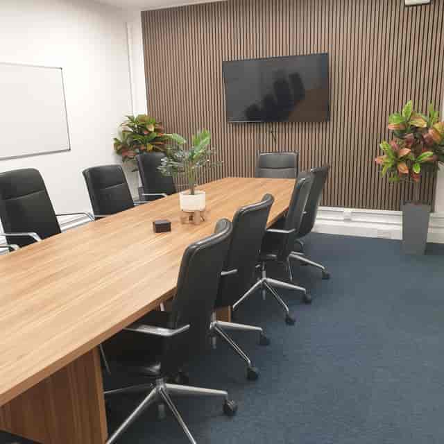 Modern boardroom with wooden table and ergonomic chairs for effective meetings.
