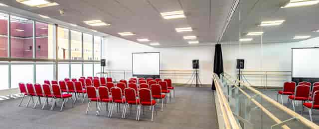 Versatile meeting space with red chairs, ideal for workshops and seminars in Leeds.