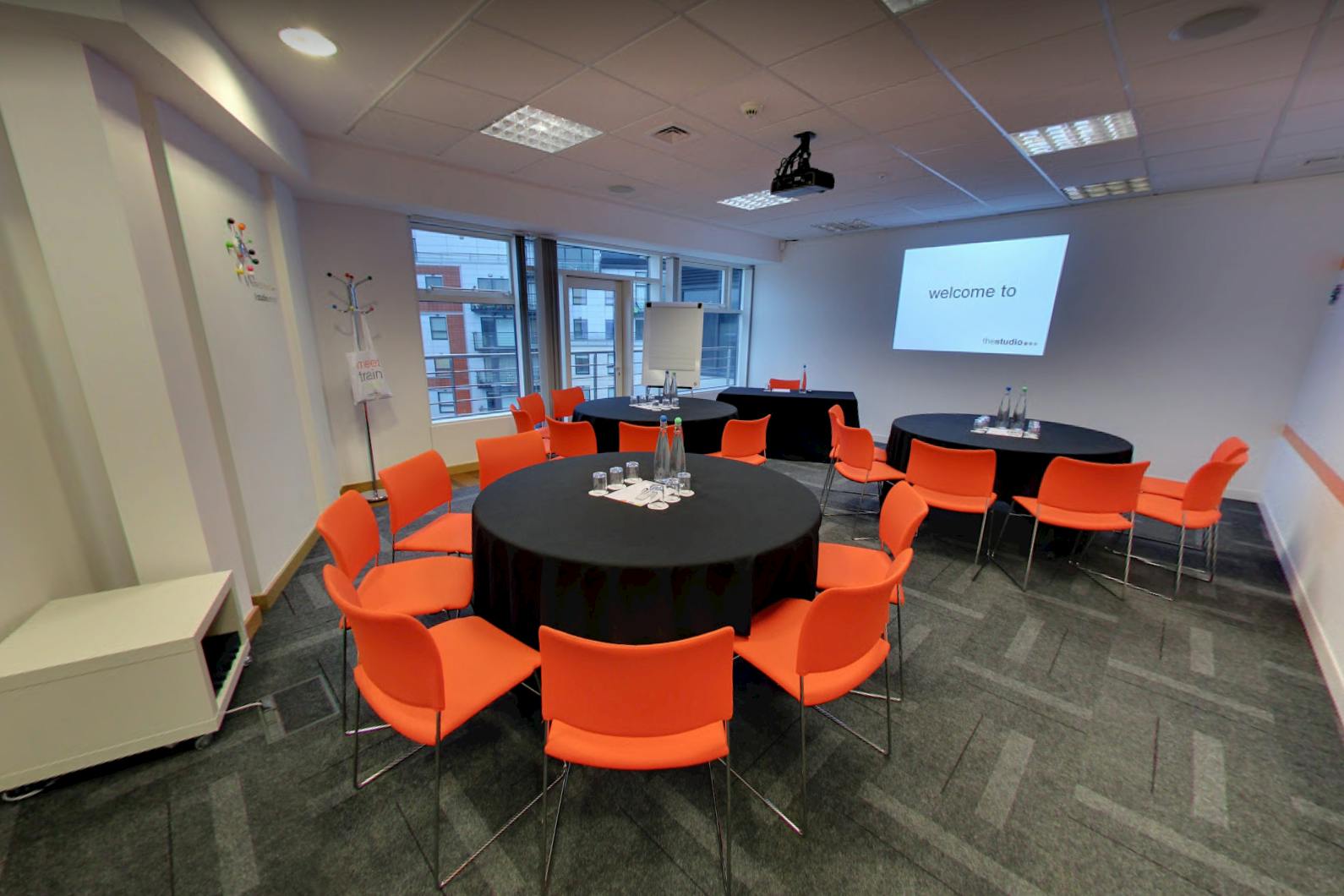 Conference center in The Studio Leeds with round tables, ideal for workshops and meetings.