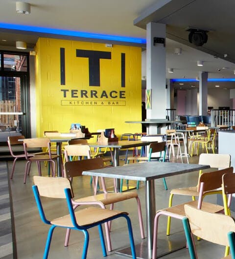 Vibrant dining space with yellow wall, perfect for casual meetings and networking events.