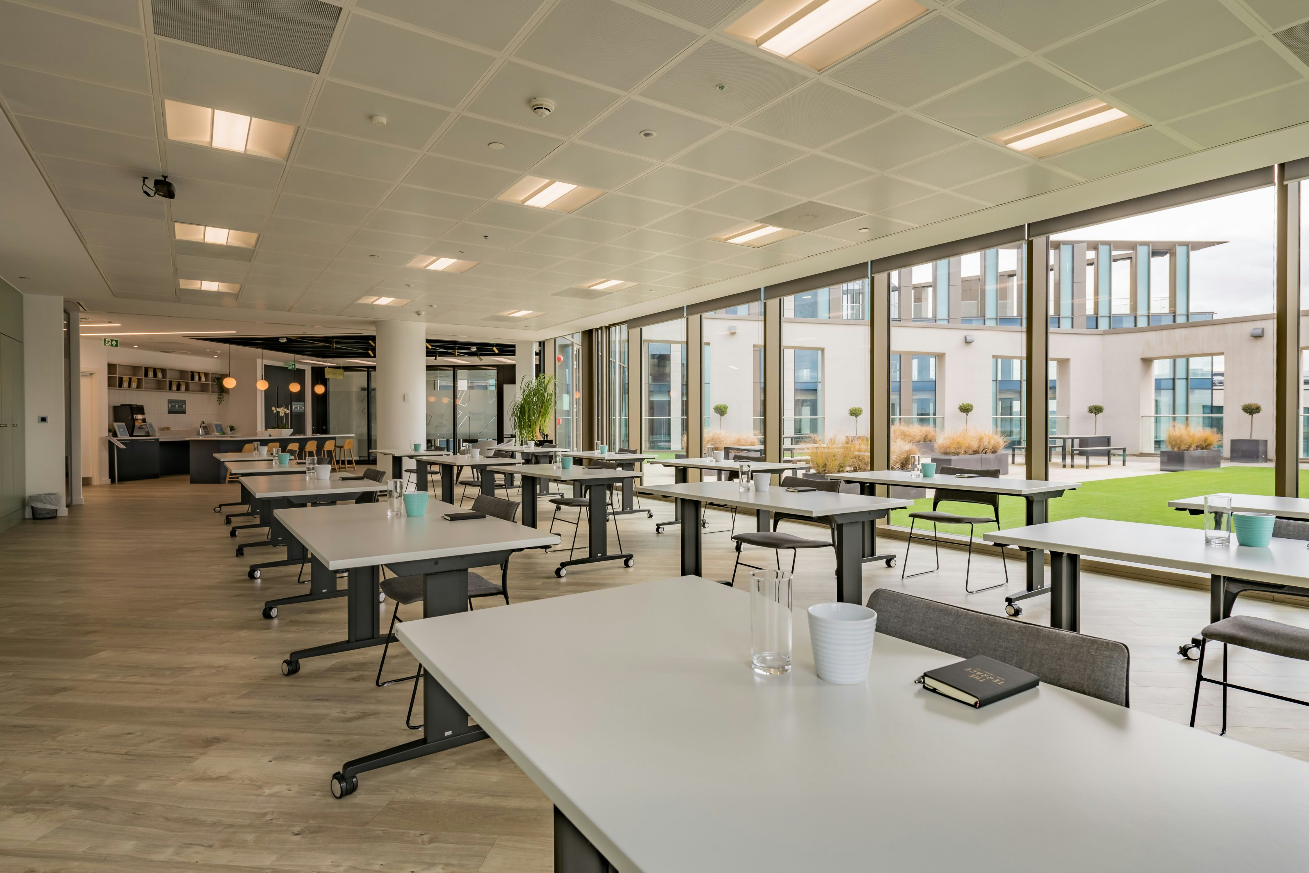 Modern meeting space with large windows, ideal for workshops and brainstorming sessions. - Banner