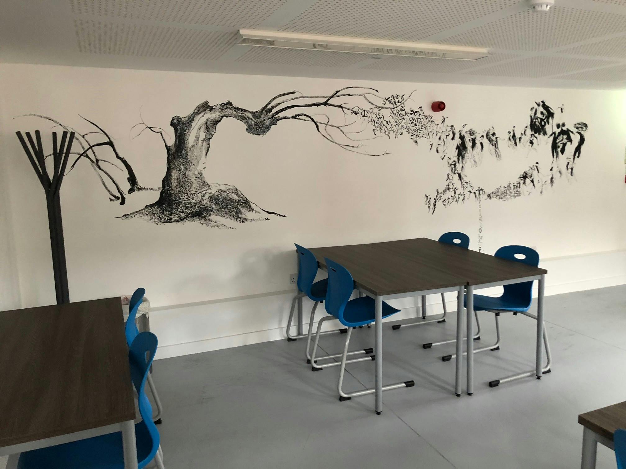 Creative meeting space with tree mural at Institut français du Royaume-Uni for workshops.