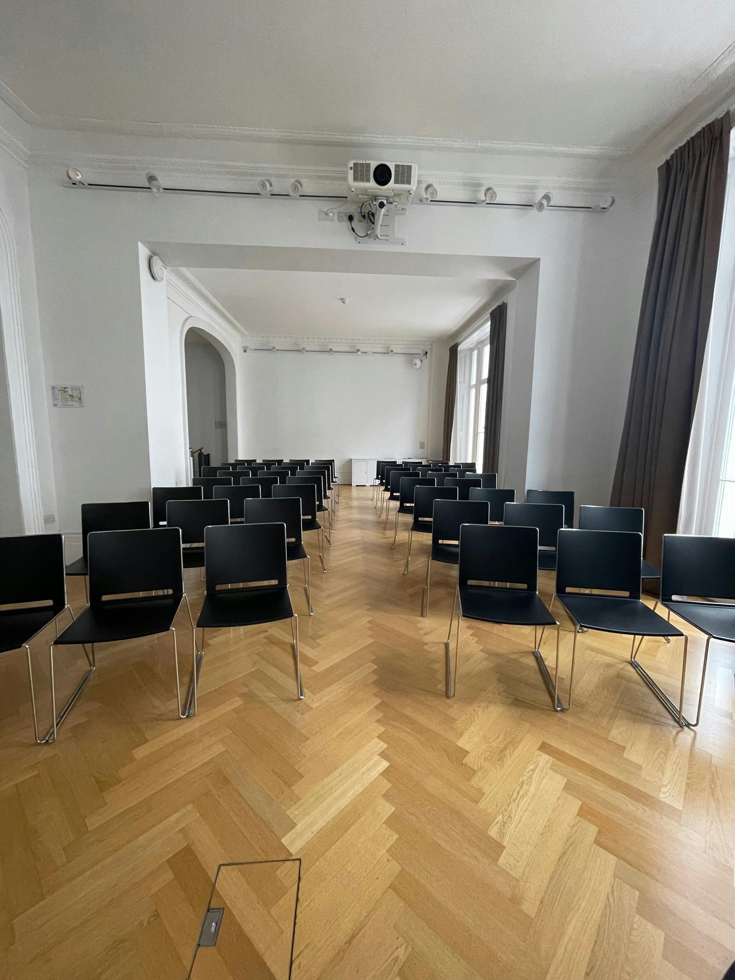 Les Salons meeting space with black chairs, ideal for workshops and presentations.