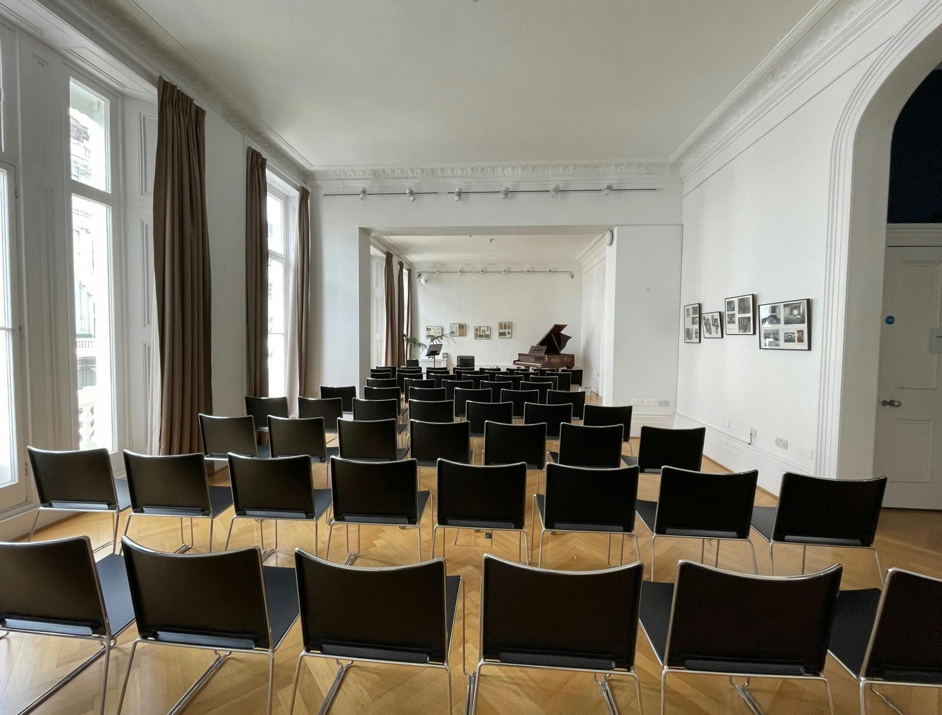 Event space at Institut français, featuring sleek black chairs and elegant piano.