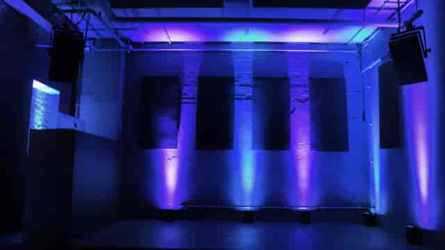 Modern event space with blue lighting, ideal for corporate meetings and creative events.