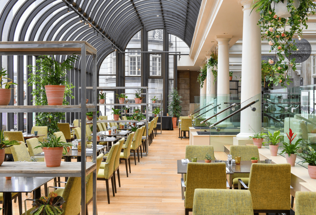Modern event space with glass atrium, ideal for meetings and upscale events. - Banner