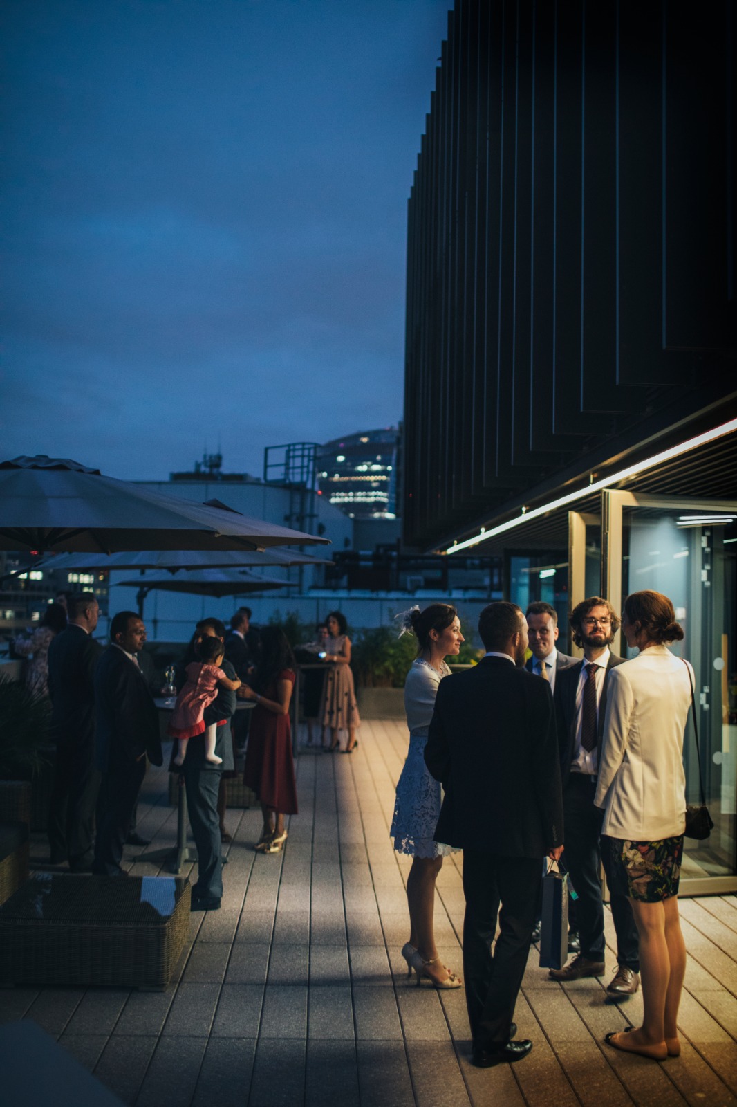 Vibrant rooftop wedding event at dusk with city skyline backdrop, ideal for networking. - Banner