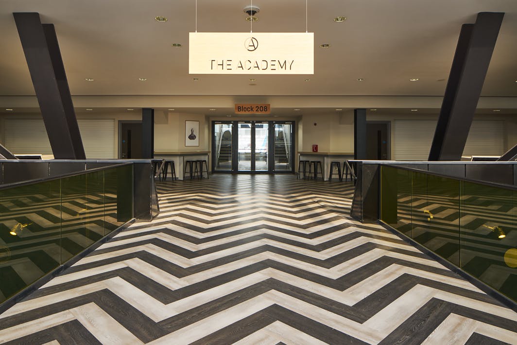 Modern event space in London Stadium with chevron-patterned floor for conferences and gatherings.