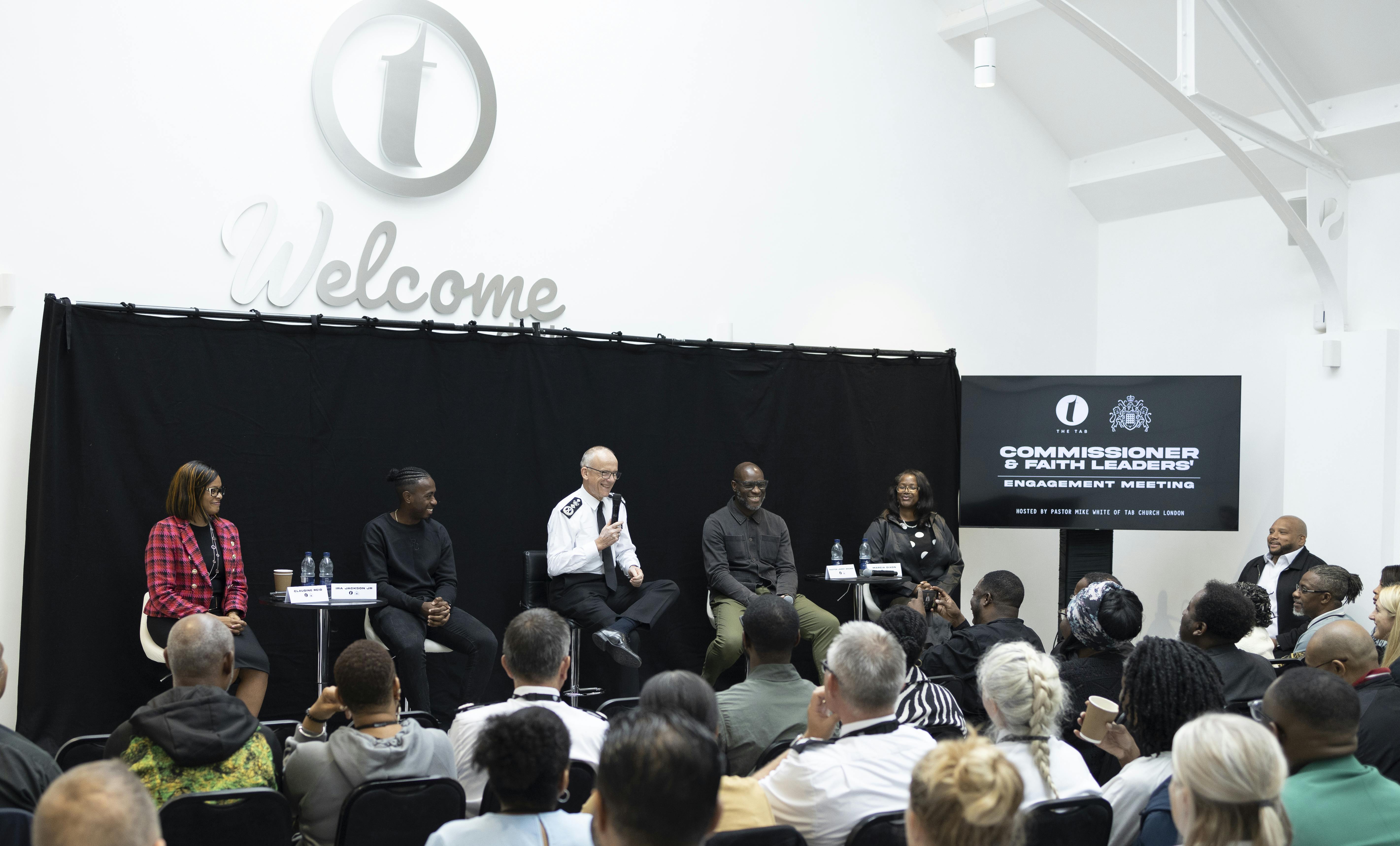 Panel discussion in The Atrium, featuring diverse speakers and professional branding.