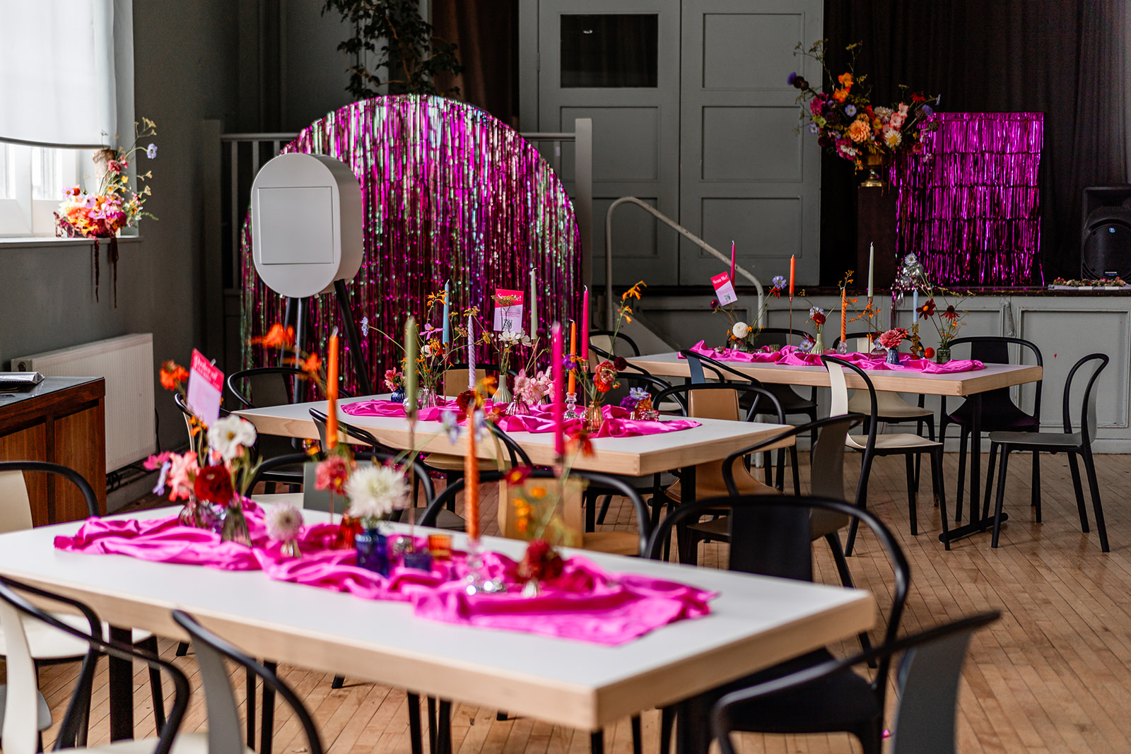 Vibrant event space at Refettorio Felix with pink decor for a festive celebration. - Banner