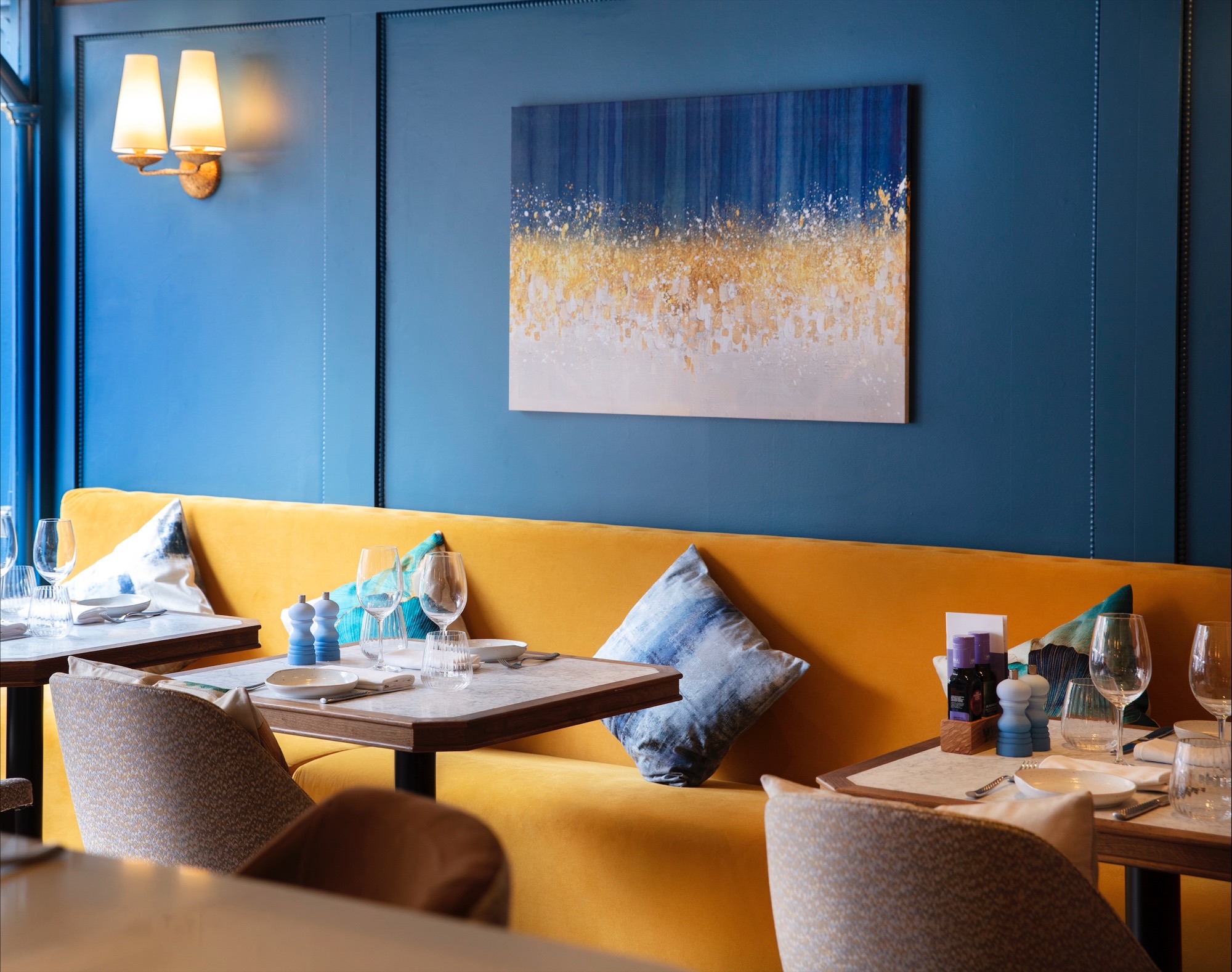 Stylish dining area with yellow seating for intimate meetings and events at Bellazul.
