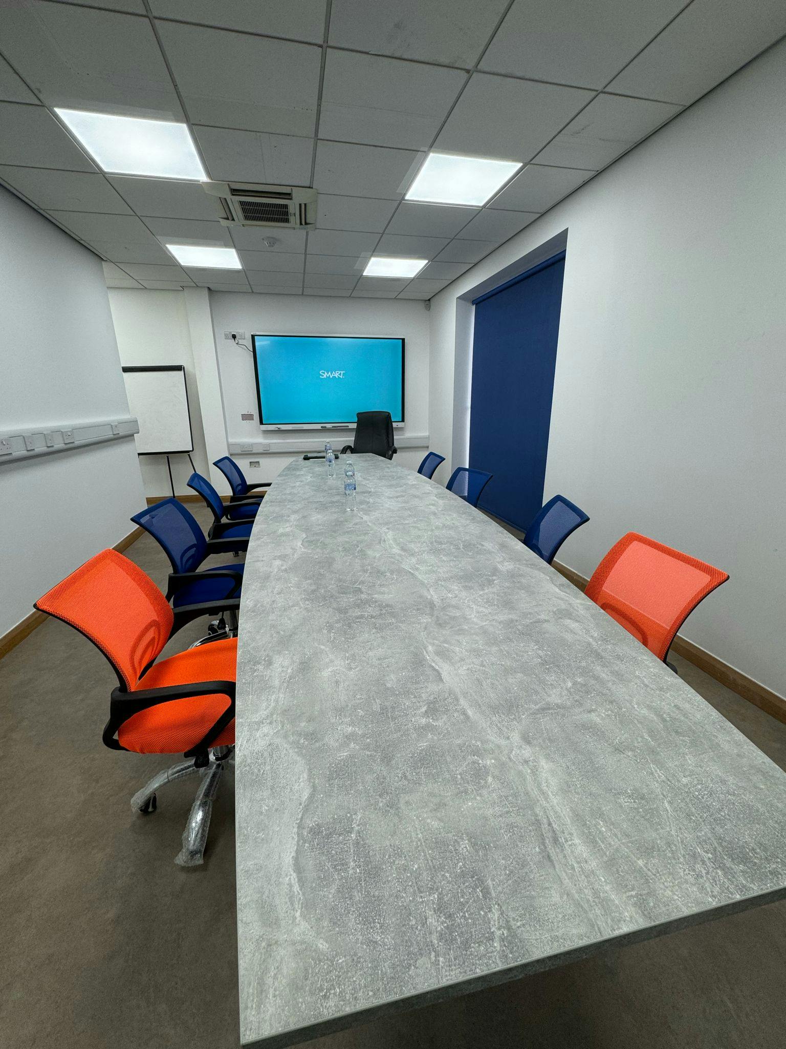 Modern conference room with oval table, ideal for meetings and presentations.