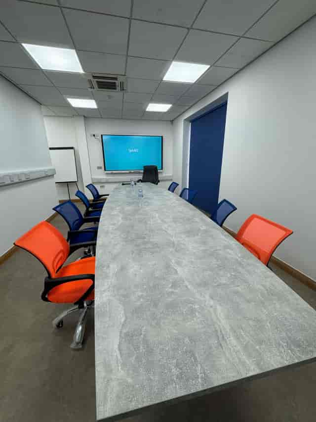 Modern conference room with oval table, ideal for meetings and presentations.