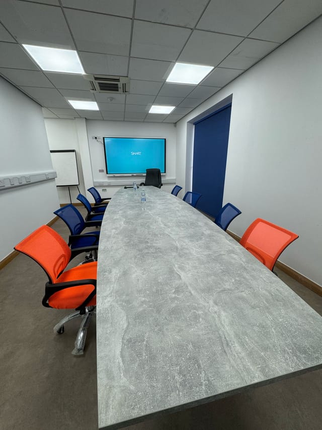 Modern conference room with oval table, ideal for meetings and presentations.