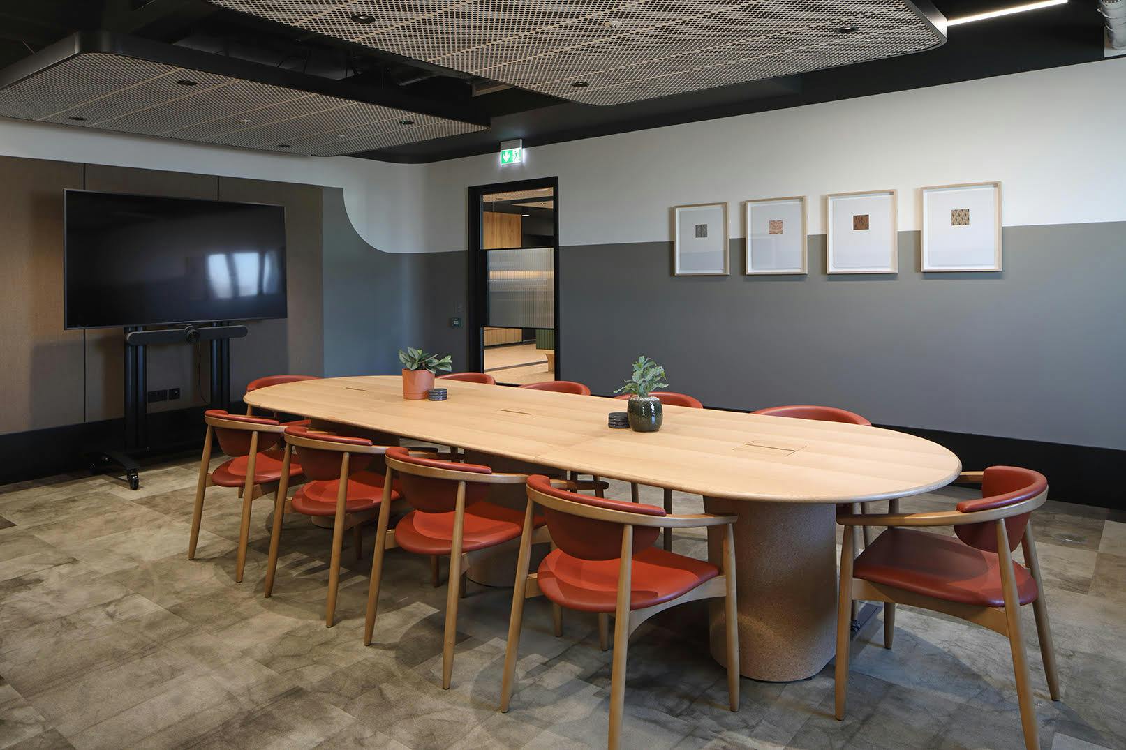 Modern meeting room with oval table, ideal for collaboration and presentations.