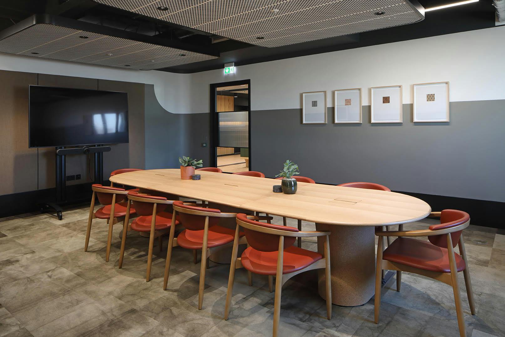 Modern meeting room with oval table, ideal for collaborative events and presentations.