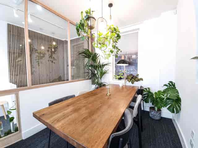 Modern meeting room with wooden table, ideal for collaboration and brainstorming.