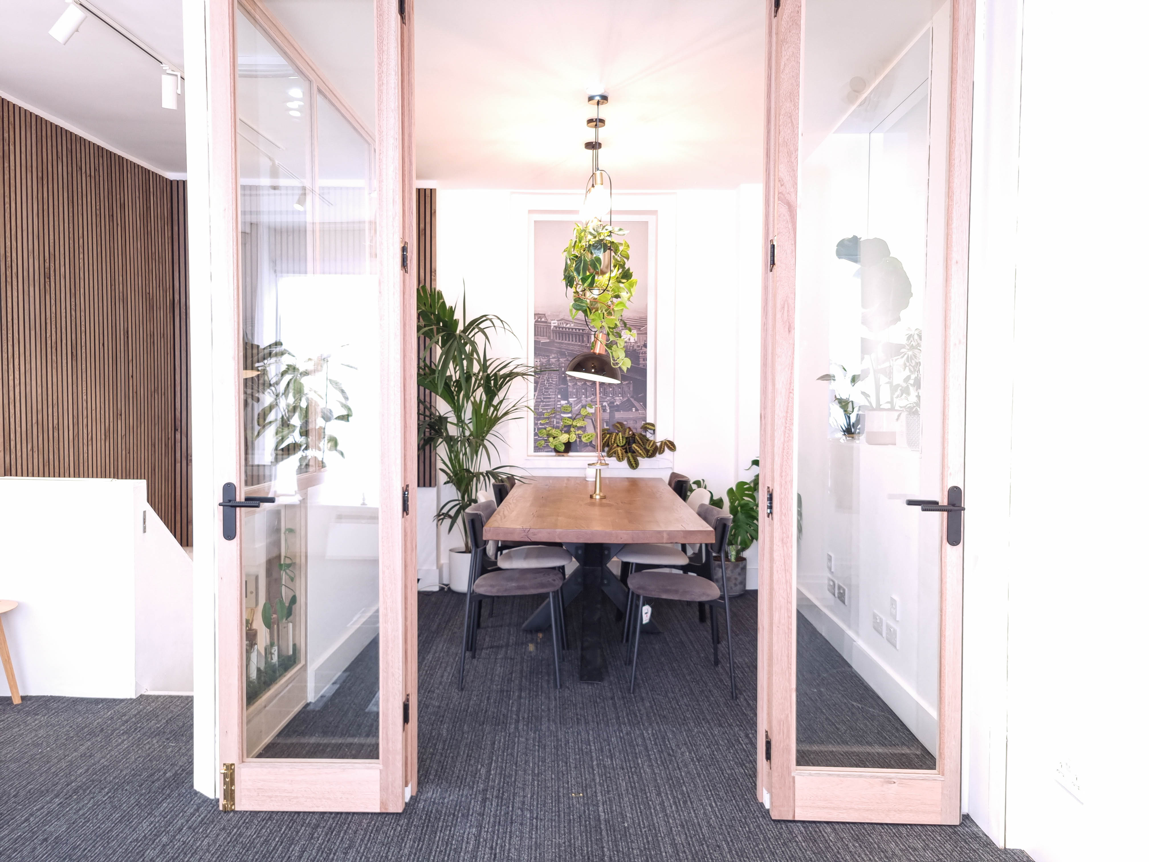 Modern meeting room with wooden table, ideal for collaborative brainstorming sessions.