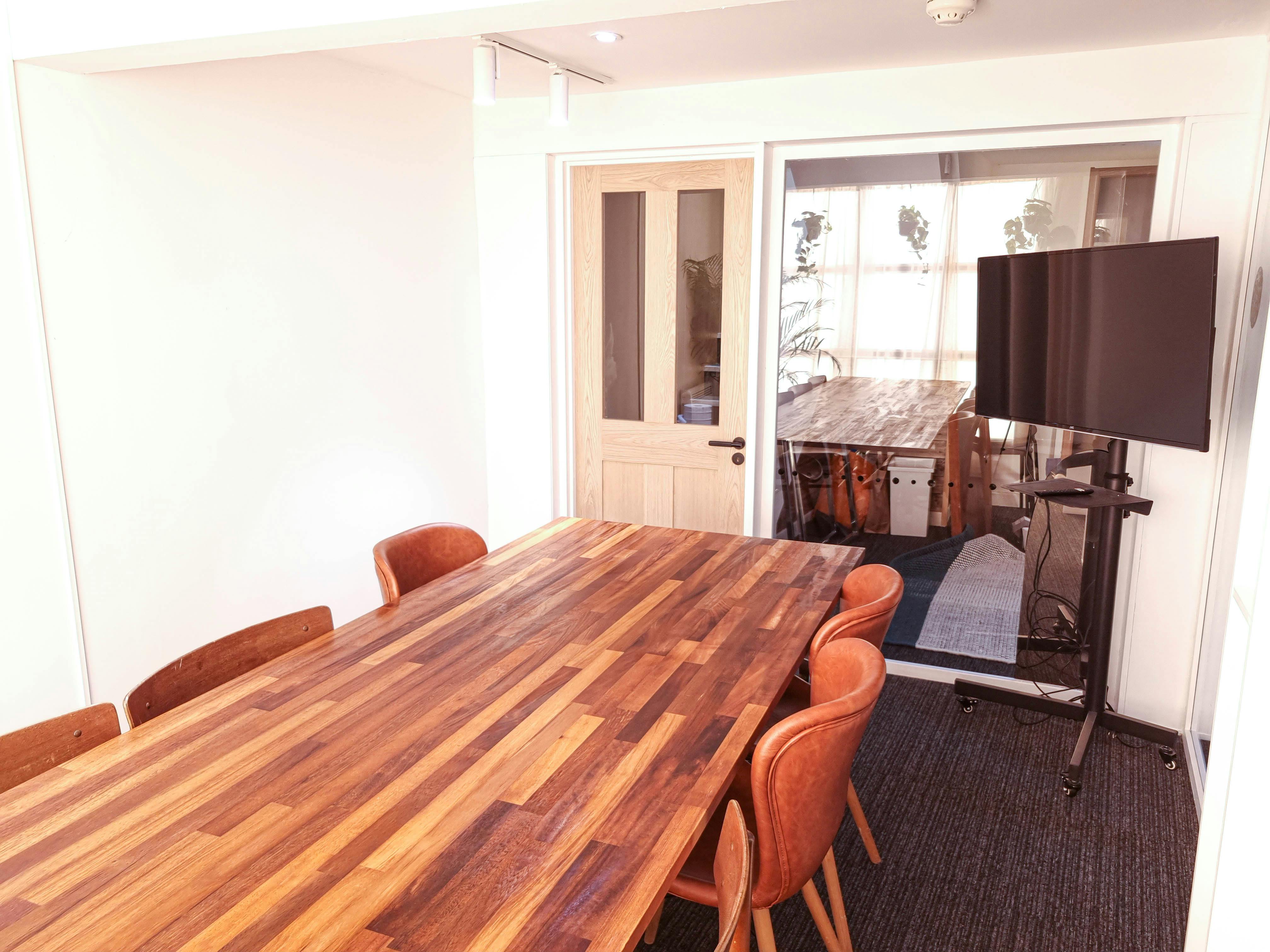 Meeting Room 2 in The Travel Cafe Lounge with a large wooden table for meetings.