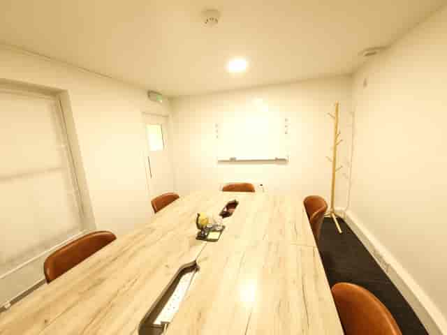 Modern meeting room with wooden table and leather chairs for strategic planning.