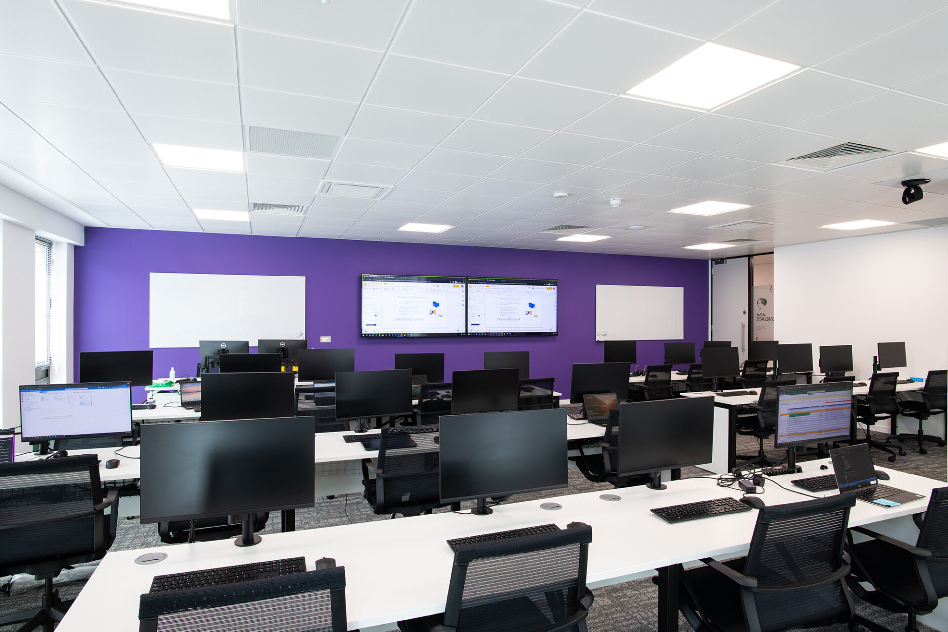 Modern training facility with workstations, ideal for hybrid meetings and tech events. - Banner