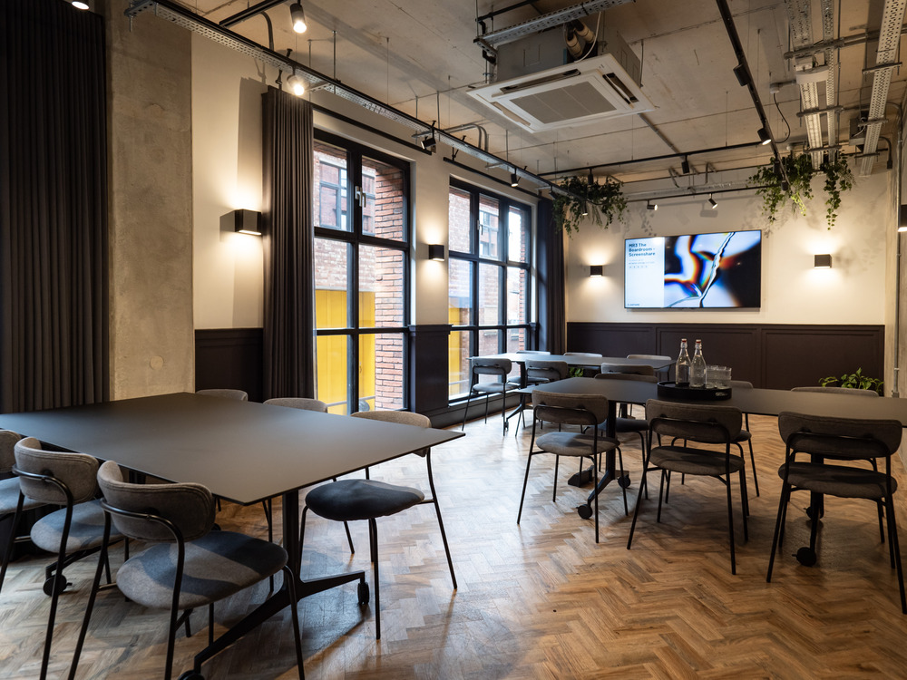 Modern meeting space with modular tables and natural light for corporate events. - Banner