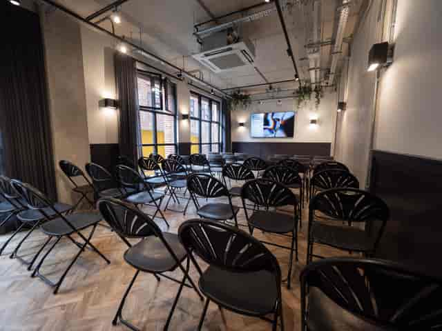 Versatile meeting space with black folding chairs, ideal for corporate events and presentations.