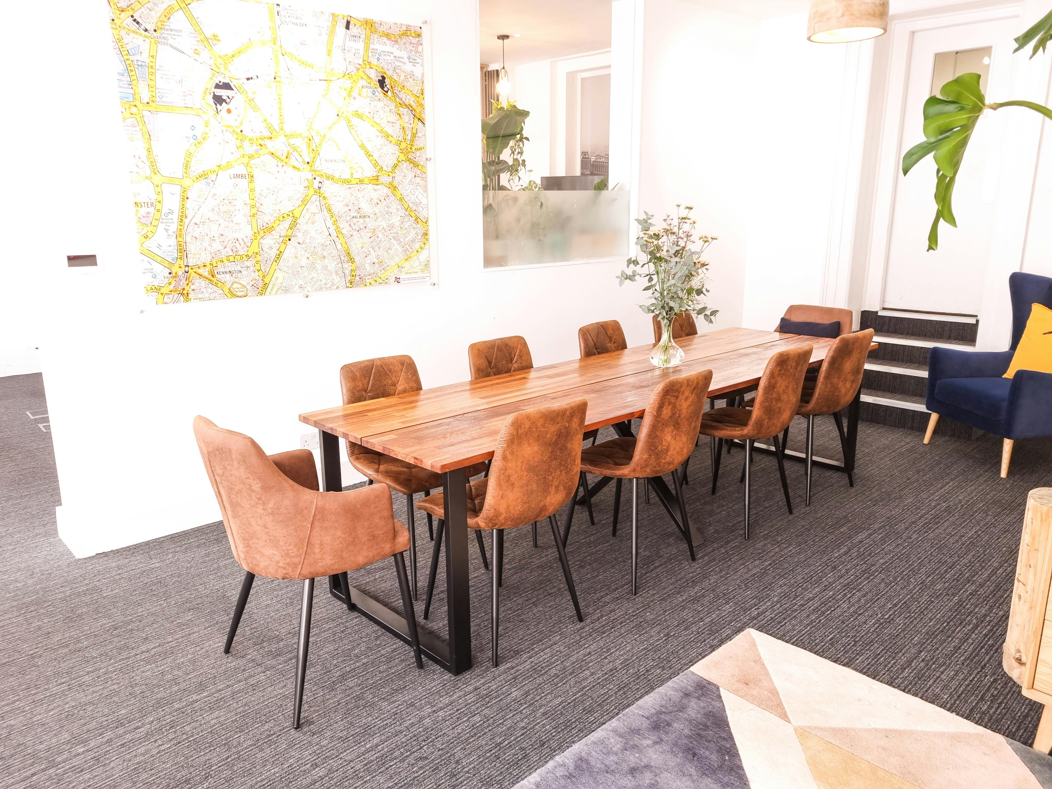 Modern meeting space with wooden table and stylish chairs at The Travel Cafe Lounge.