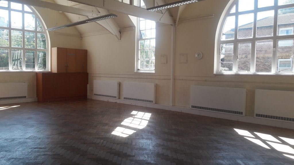 Spacious Mortlake Hall meeting room with large windows, perfect for workshops and conferences.