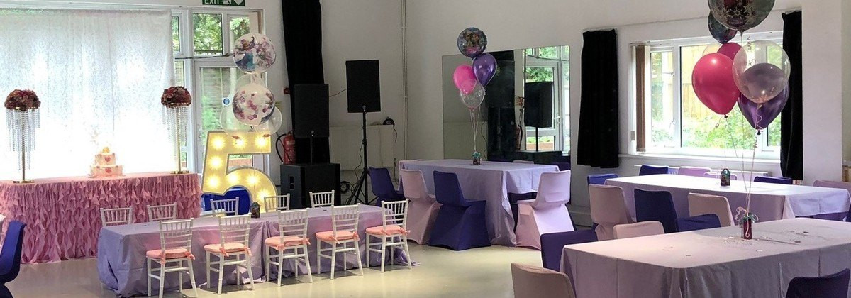 Vibrant birthday party setup at Troy Hall with colorful balloons and a "5" sign. - Banner